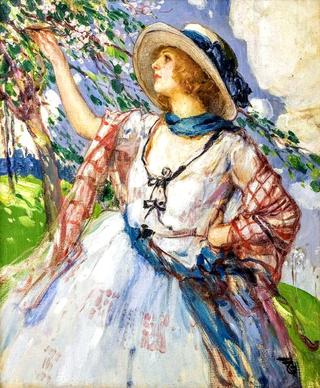 A young woman with a hat and a white dress standing in front of a blooming tree