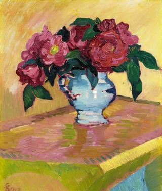 Red peonies in pale blue jug on a table