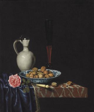 A wan-li bowl with walnuts, a wine glass, an ivory-handled knife, a Delft stoneware jug and a rose