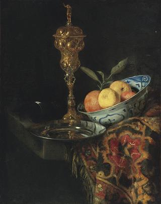 A still life with a bowl of oranges, a pewter plate and a gilt cup