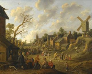 A wide street through a village filled with numerous figures and overlooked by a windmill