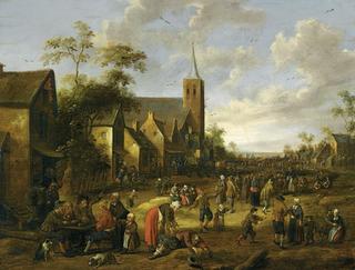 A busy village stret with numerous figures, peasnts eating and drinking at a table in foreground