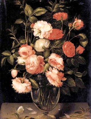 Red, pink and white roses in a glass vase with a butterfly on a ledge