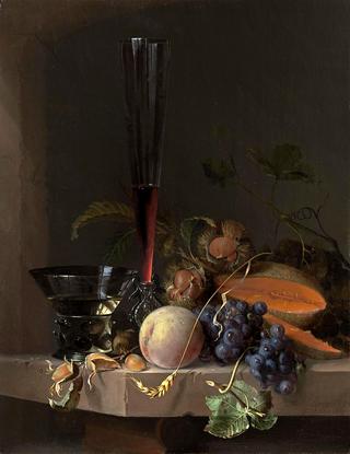 A still life of fruit and nuts and two glasses on a stone ledge before a niche